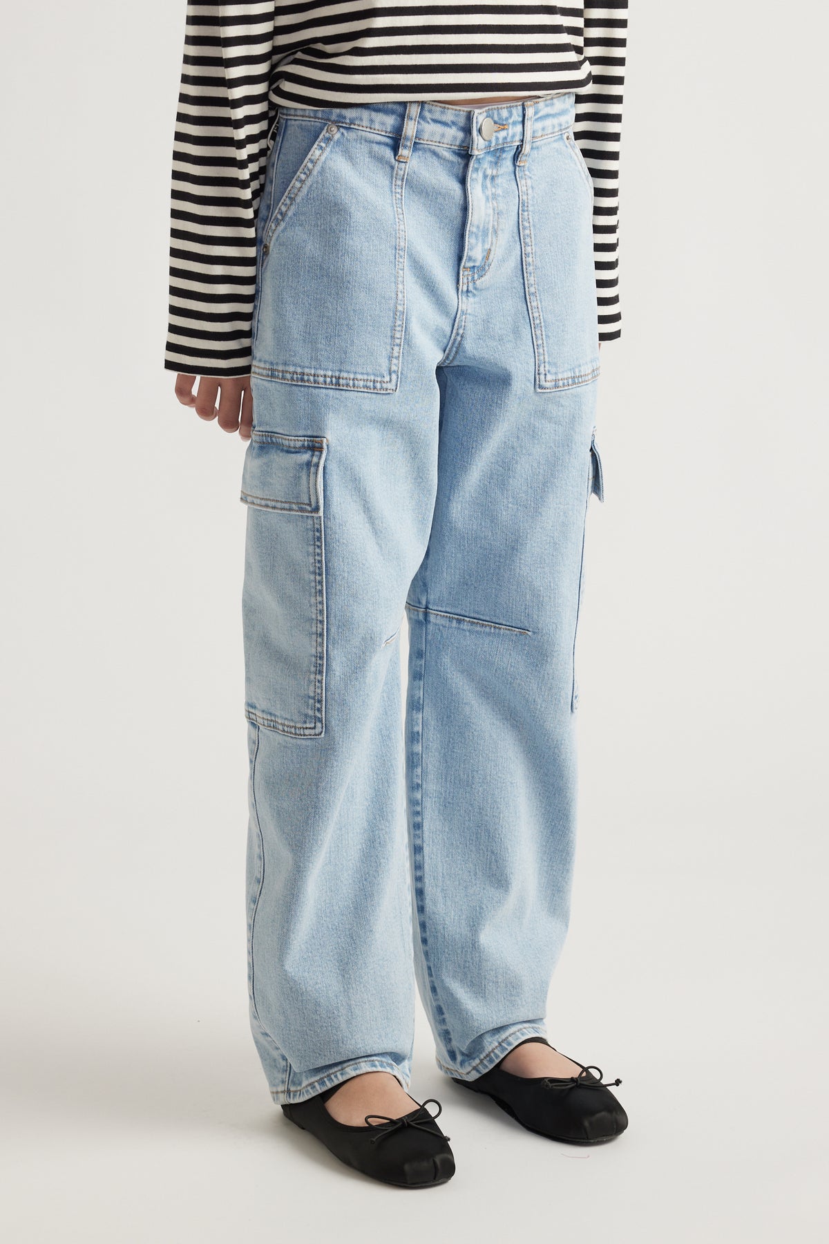 Light wash barrel-leg denim cargo jeans with patch pockets paired with black ballet flats and striped top
