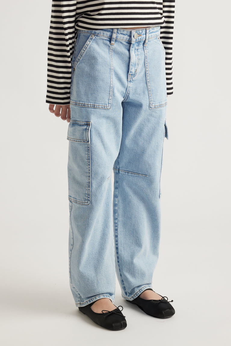 Light wash barrel-leg denim cargo jeans with patch pockets paired with black ballet flats and striped top