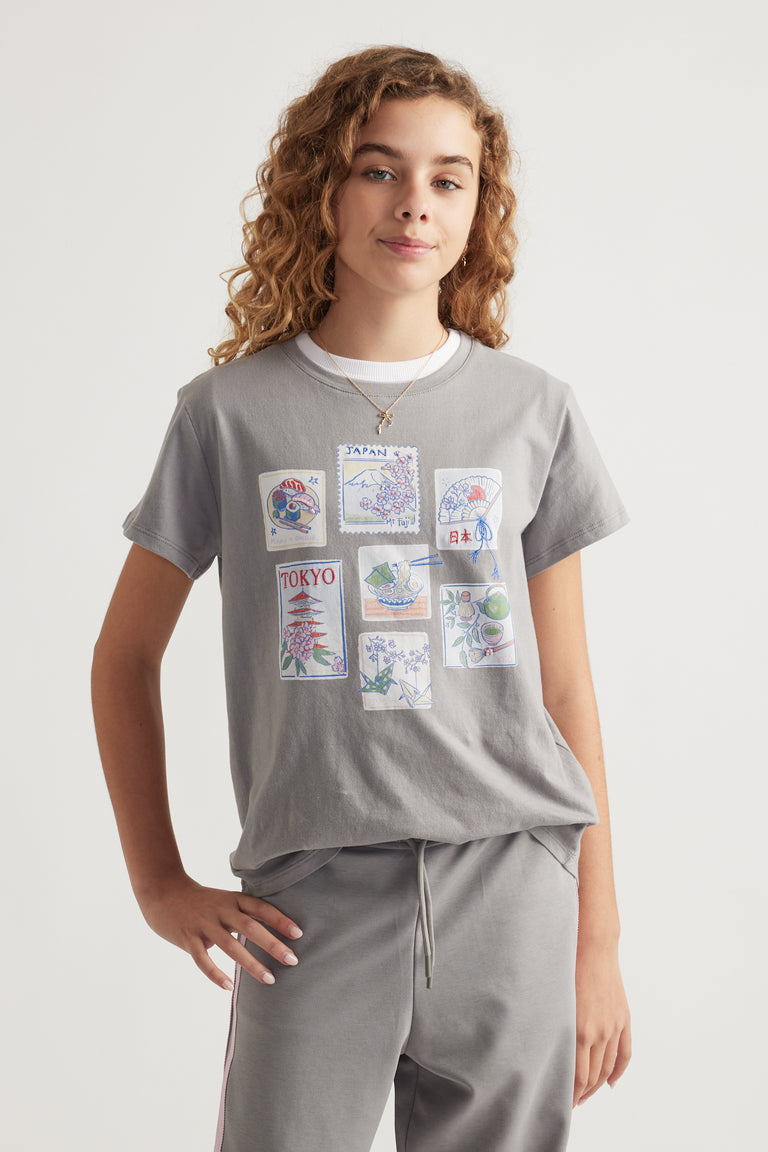 Girl wearing a relaxed grey tee with Tokyo-themed graphic prints paired with coordinating grey drawstring pants