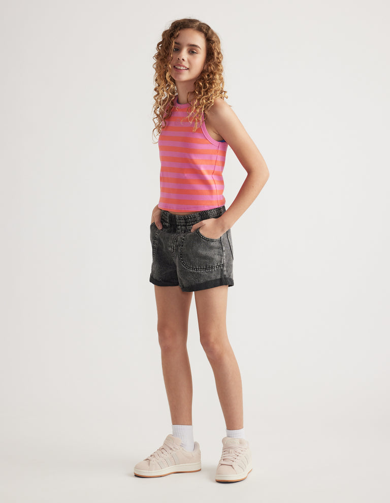 Girl wearing black denim pull-on shorts with cuffed hems, a striped tank top and sneakers