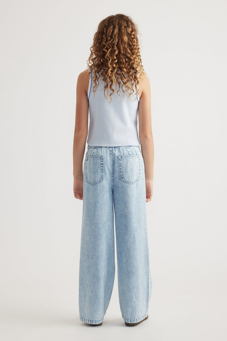 Girl seen from behind wearing a light blue ribbed scoop neck tank with wide leg jeans