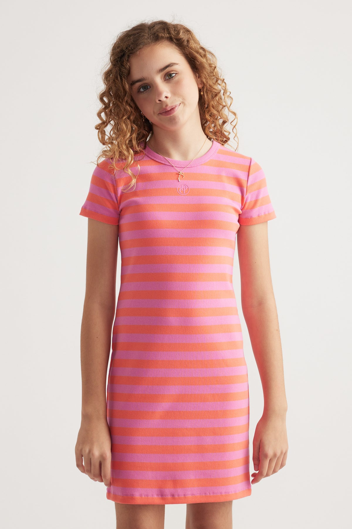Girl wearing a pink and orange striped fitted ribbed dress with short sleeves and a crew neckline