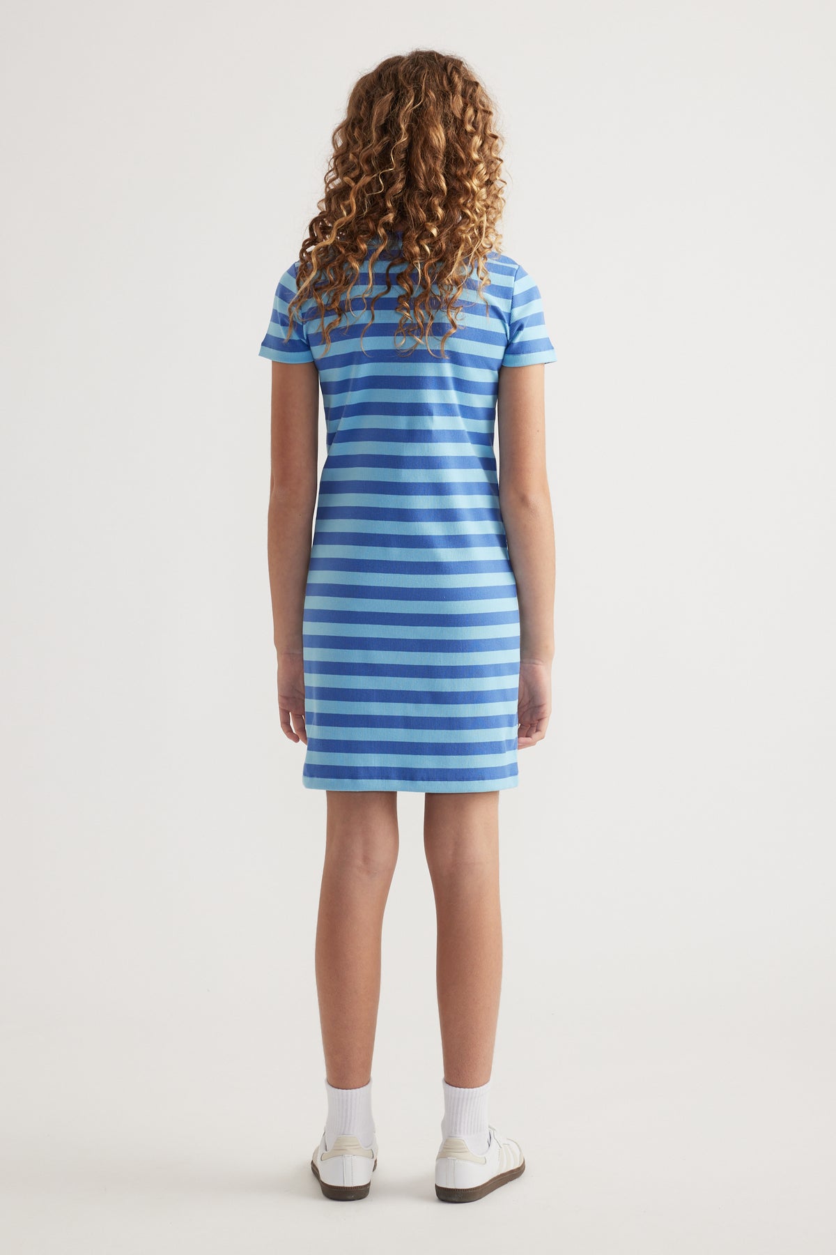 Back view of girl wearing a blue and white striped ribbed T-shirt dress with short sleeves and an above-knee hem