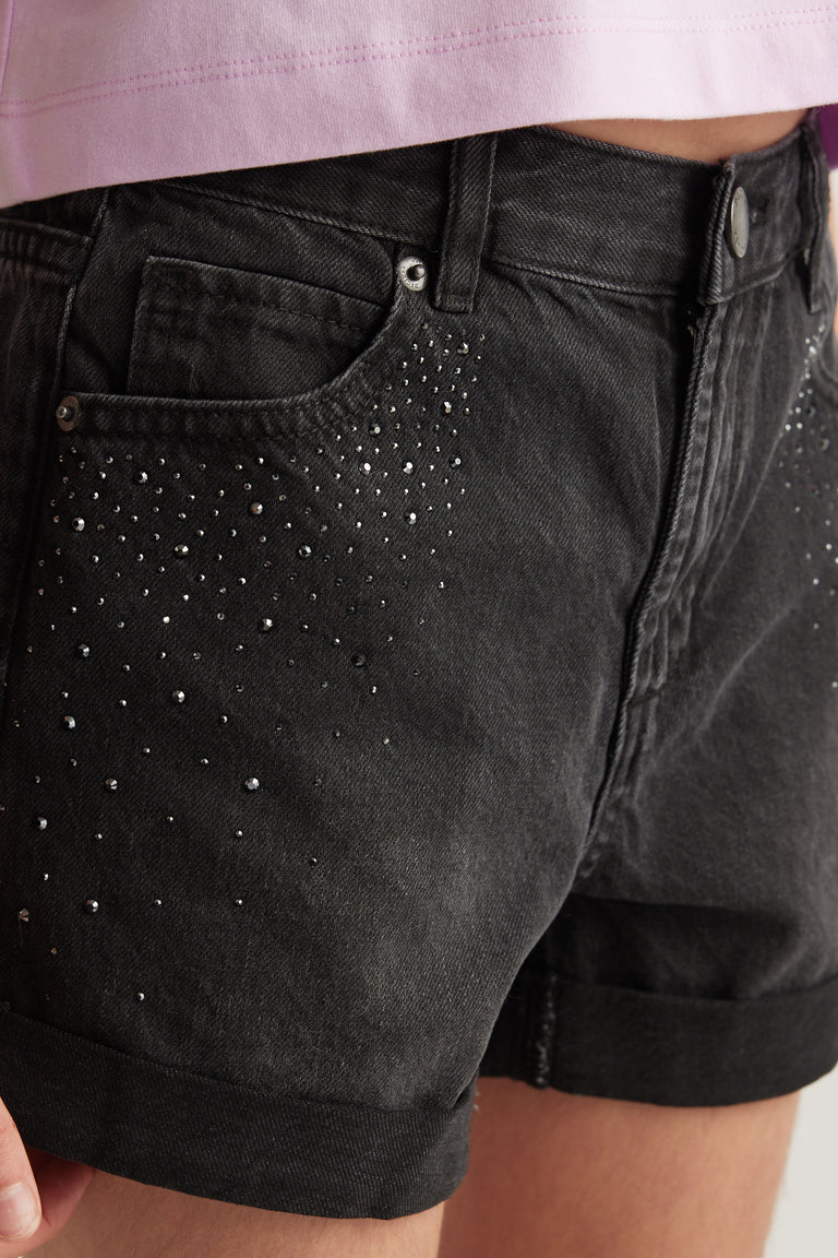 Close up of black denim shorts with rhinestone detailing a high rise waist and rolled cuffs