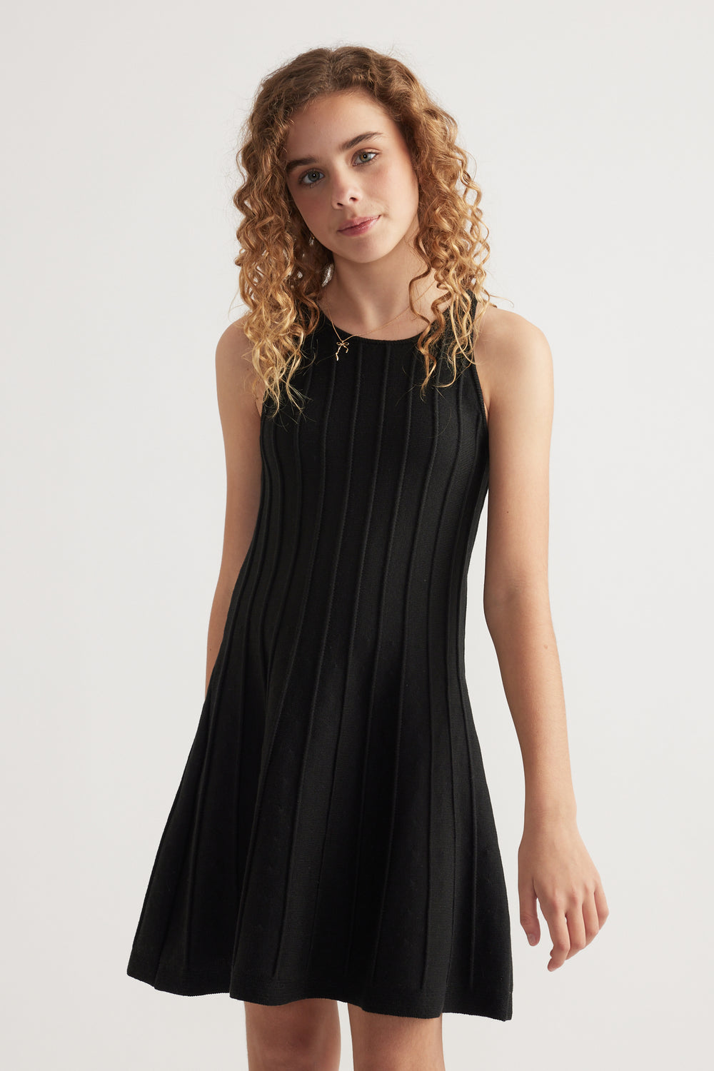 Girl wearing a black sleeveless ribbed knit fit and flare mini dress