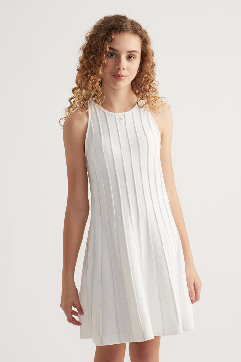 Girl wearing a white sleeveless ribbed knit fit and flare mini dress