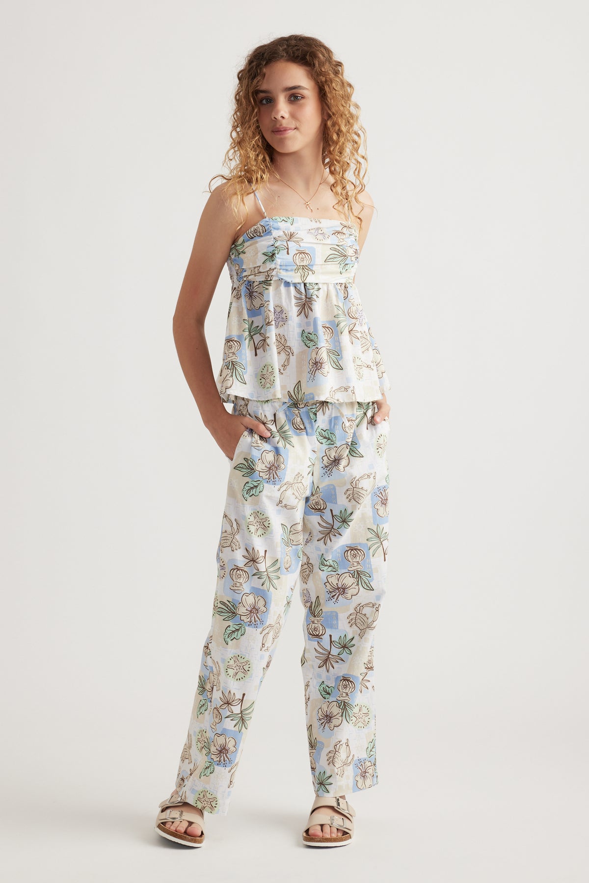 Model wearing a floral camisole with matching wide leg pants and sandals