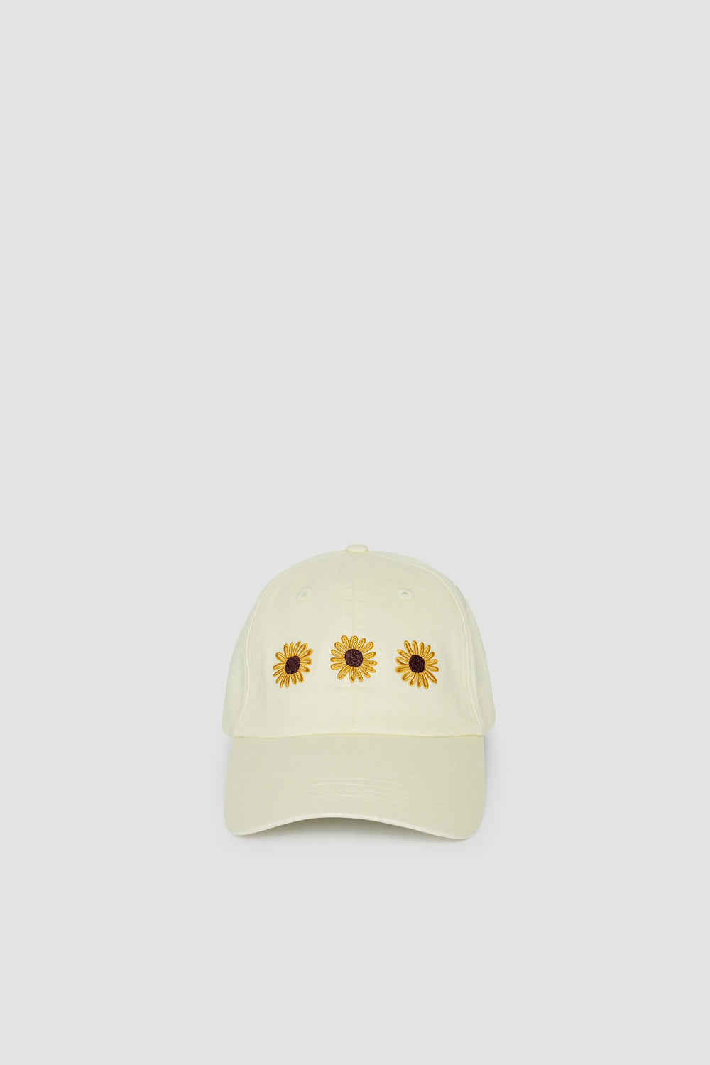Pale yellow girls baseball cap with three sunflower motifs and curved brim