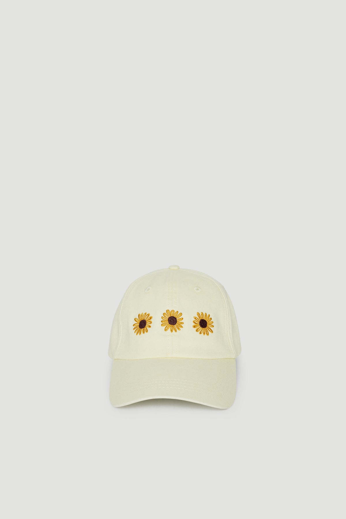 Pale yellow girls baseball cap with three sunflower motifs and curved brim