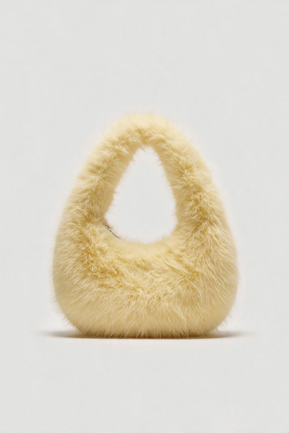 Cream fluffy shoulder bag with a rounded shape and top handle
