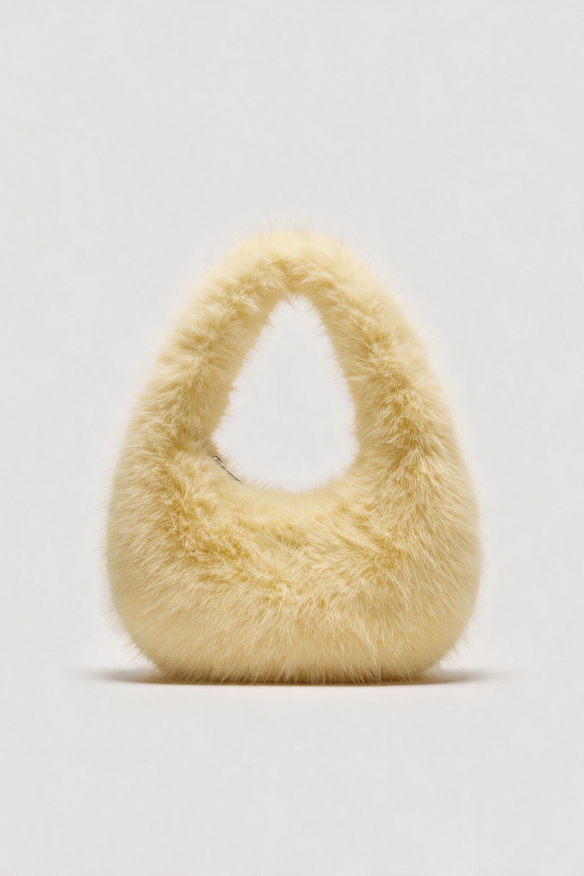 Cream fluffy shoulder bag with a rounded shape and top handle