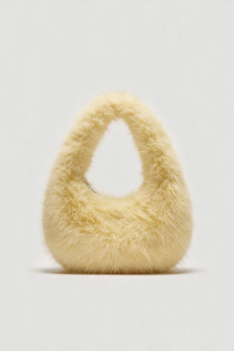 Cream fluffy shoulder bag with a rounded shape and top handle