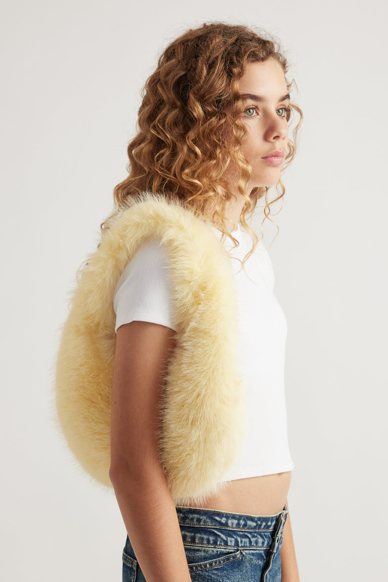 Girl wearing a cream fluffy shoulder bag with a white tee and blue jeans