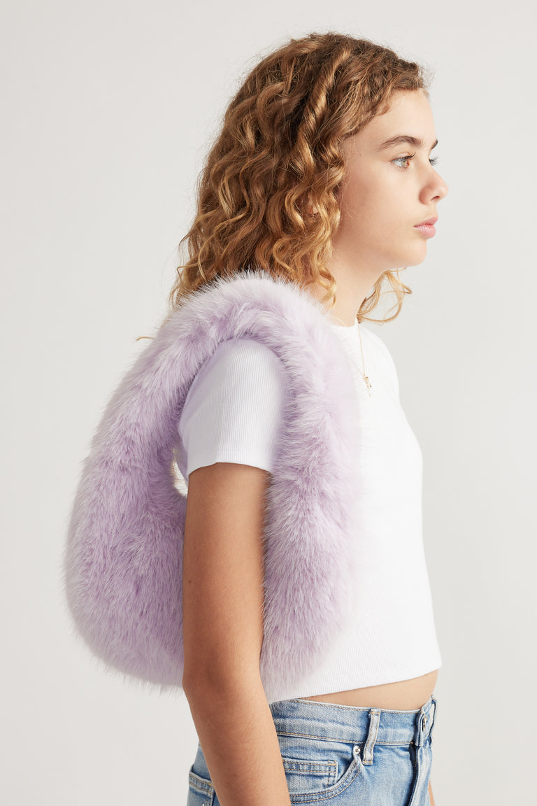 Girl wearing a lavender fluffy shoulder bag with a white tee and blue jeans