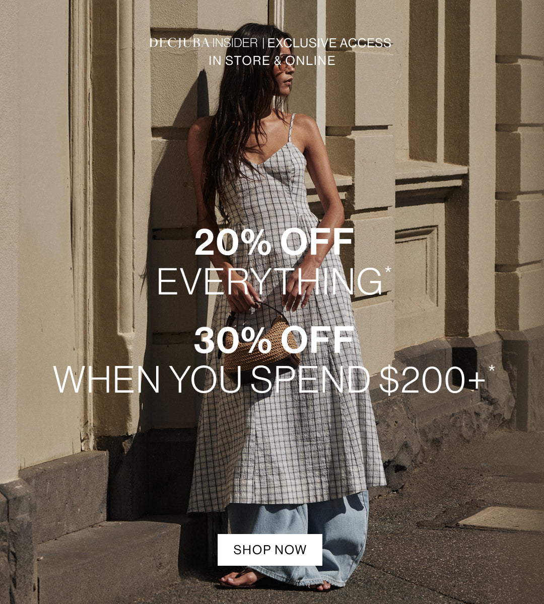 A woman wearing a sleeveless black-and-white checkered midi dress and light blue wide-leg jeans stands on a city sidewalk beside a beige building, with large promotional text overlaid: '20% OFF EVERYTHING', '30% OFF WHEN YOU SPEND $200+', and 'SHOP NOW'.